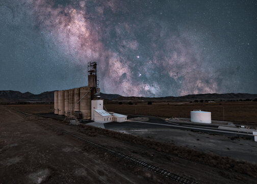View of the historic grain silo near Eureka, under a vibrant Milky Way galaxy, with desert landscape and mountains in the background, Utah, United States.