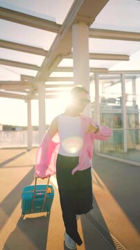 Caucasian woman pulling a suitcase and running, late for flight. Slow motion