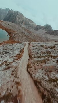 FPV drone flying along the surface of mountain cliffs of Cristallo mountain.
