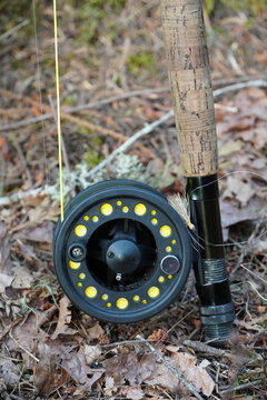 Fly-fishing rod and reel with Madam X dry fly on a forest floor