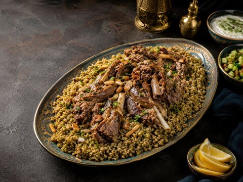 Syrisches Freekeh mit zart geschmortem Lamm, ger&ouml;steten Pinienkernen und frischen Kr&auml;utern, edel angerichtet als aromatisches orientalisches Festgericht.