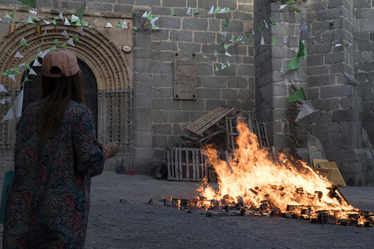 Traditional midsummer bonfire burning brightly outside the historic Church of San Juan Bautista during the Night of San Juan festival in Avila, Castile and Leon, Spain.
