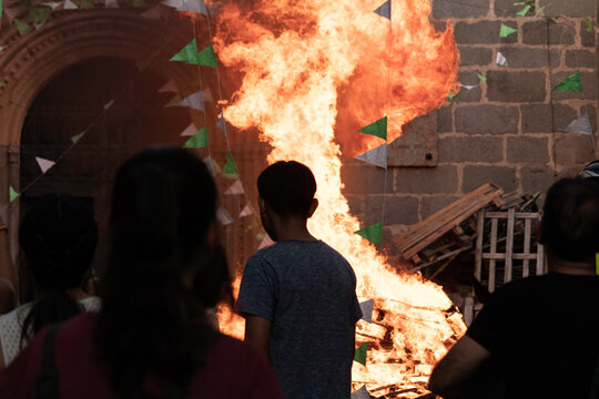 Traditional midsummer bonfire burning brightly outside the historic Church of San Juan Bautista during the Night of San Juan festival in Avila, Castile and Leon, Spain.