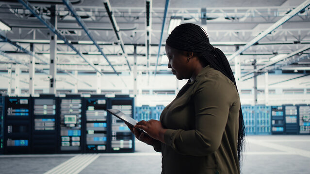 IT specialist uses tablet in a data center to upgrade server hardware and improve workload capacity.