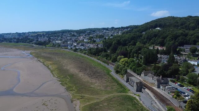 High aerial view of the seaside town of Grange Over Sands in Cumbria with the railway station and town buildings alongside the beach