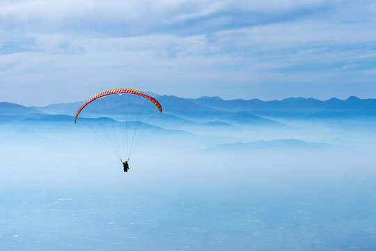 Paragliding over mountains and clouds
