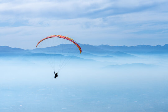 Paragliding over mountains and clouds