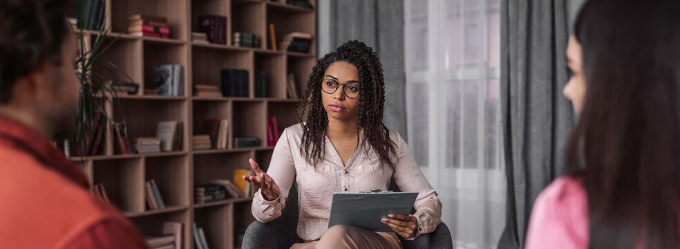 Focused Female Therapist Engaging With Couple In Counseling Session At Professional Office Environment, Aiding Communication And Support For Relationship. Mental Health Concept.