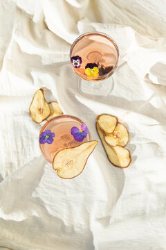 Two rose wine glasses on white fabric top view. Summer cocktails
