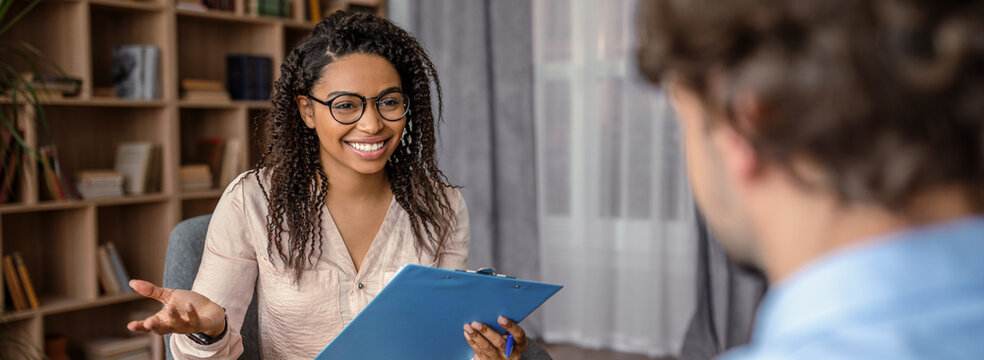 Smiling Black Female Therapist Engaging With Male Client During Session In Cozy Office Setting. Showing Empathy And Understanding While Discussing Mental Health Issues. Therapy Concept.