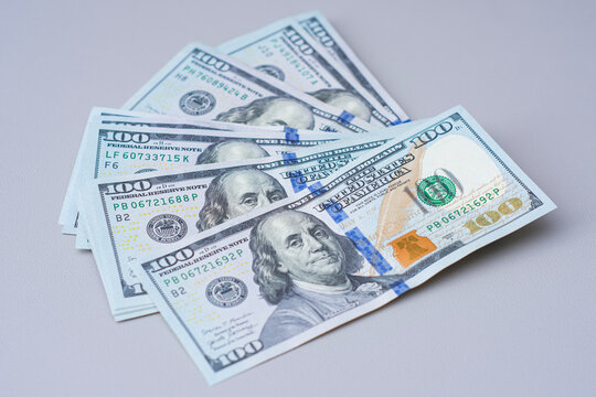 Stack of one hundred US dollar banknotes on neutral background. Cash savings, personal finance, investment, business payment and wealth management concept for banking and financial planning.