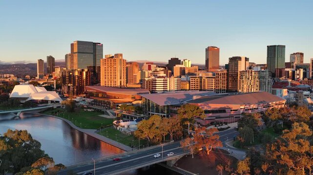 Adelaide City, South Australia &ndash; 4K aerial drone footage of CBD skyline, Towers, River Torrens, Convention Centre, Elder Park, city bridges and golden sunset cityscape.