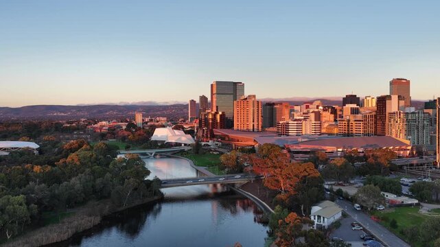 Adelaide City, South Australia &ndash; 4K aerial drone footage of CBD skyline, Towers, River Torrens, Convention Centre, Elder Park, city bridges and golden sunset cityscape.