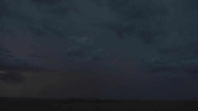 Electric thunderclouds flashing over dark night sky