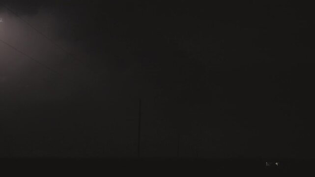 Intense lightning illuminates towering thunderclouds at night