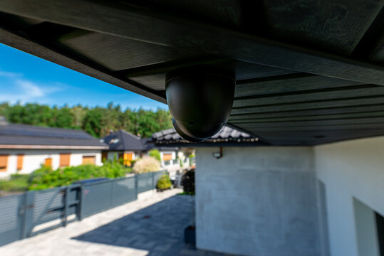 Security dome camera monitoring modern home yard