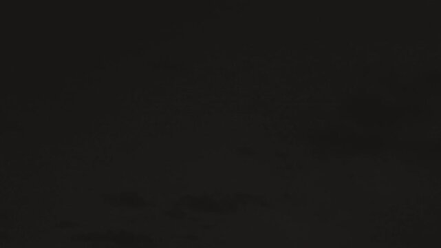 Ominous cloud layers lit by powerful lightning in night sky