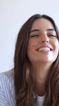 Gorgeous young woman with a genuine smile looking at the camera on a white background