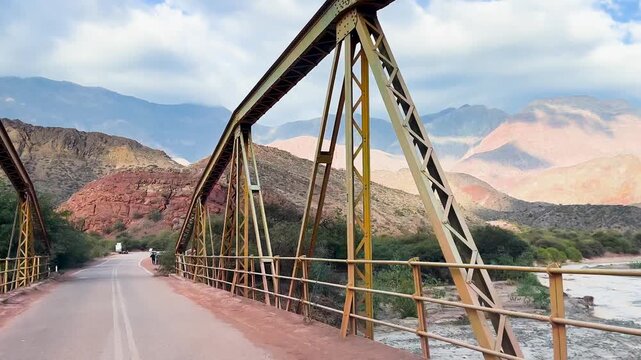 Traveling across an old iron bridge in a mountainous landscape in Salta.Winter Adventure tourism in Salt, Argentina. 4k horizontal footage.Landscape of Salta.
