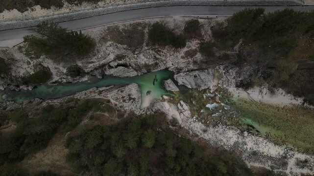 Aerial view of the turquoise waters of the Great Soca Gorge flowing through rocky terrain near the road in Soca, Tolmin, Slovenia.