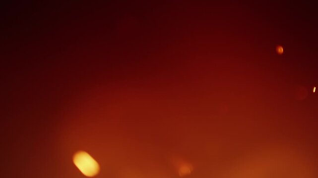 Hellish hot fiery background with smoke and sparks. Out of focus blazing fire creating an atmosphere of warmth and heat. Orange glow of flickering flames. Hell fire backgrounds in seamless loop.