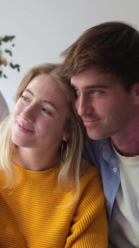 Happy young caucasian couple showing affection and intimacy. Boyfriend and girlfriend enjoying a quiet romantic moment, cuddling together and sharing a lovely connection at home