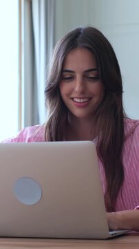 Beautiful smiling woman using a laptop computer for online shopping, browsing social media, or working from home, showcasing a modern digital lifestyle with a happy and relaxed expression