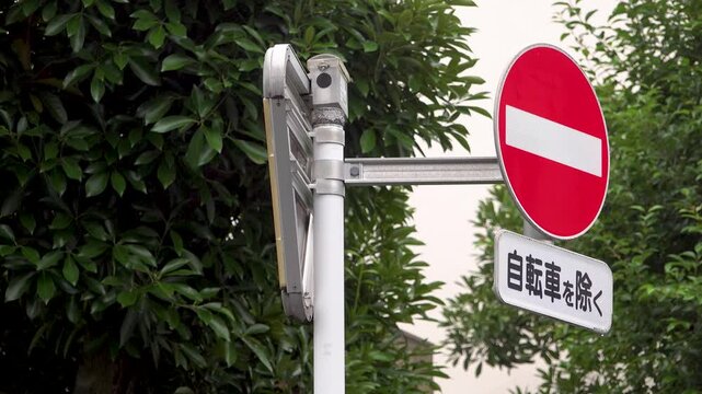 Right-positioned no entry road sign with bicycle exception in light rain on a Tokyo morning