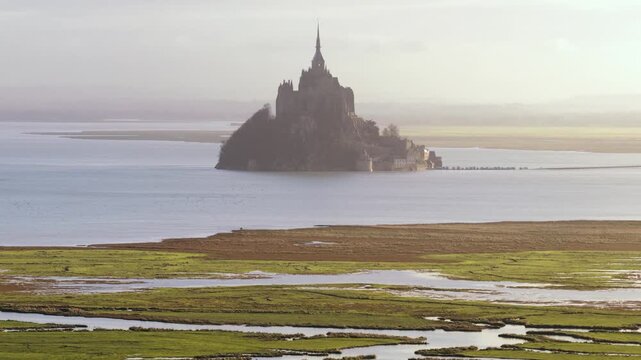 Aerial view of the historic abbey and village of Mont Saint-Michel surrounded by tidal flats and marshlands in the bay of Mont Saint-Michel, Mont Saint-Michel, Normandy, France.