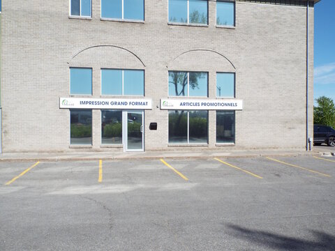 Gatineau,Quebec, Canada &ndash; May 17, 2026:A storefront with signage for large format printing and promotional items, "articles promotionnels", in a business building at 120 rue Jean-Proulx.