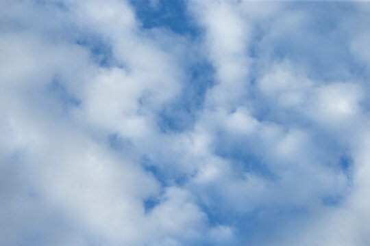 Beautiful blue sky with soft white fluffy clouds background.