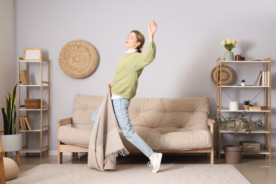 Young woman tripping over plaid at home. Trauma concept