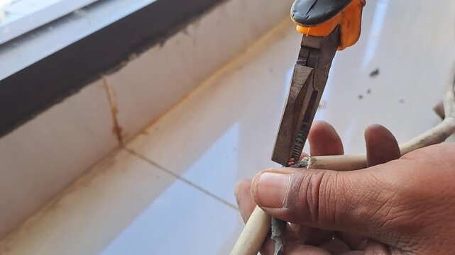 Technician connecting electrical wires for outlet using pliers and hot glue gun. Wiring installation and insulation process. Electrician stock video 4K for DIY, renovation, safety, construction, maint