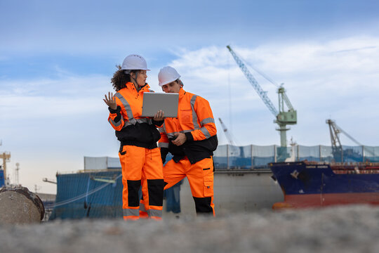 Port workers team inspecting freight shipping, Logistics engineers with laptop to coordinate operations at a shipping port, Team of marine logistics specialists managing shipping cargo at the harbor