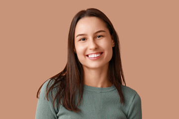 Fototapeta premium Beautiful young woman on brown background