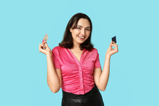 Young woman with condoms on blue background. Safe sex concept