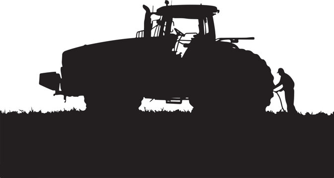Silhouette of a man working with a shovel next to a tractor