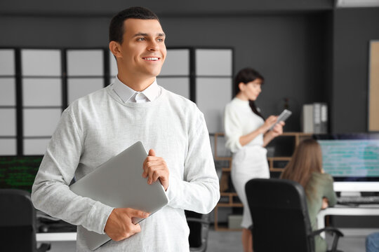 Male programmer with laptop in office