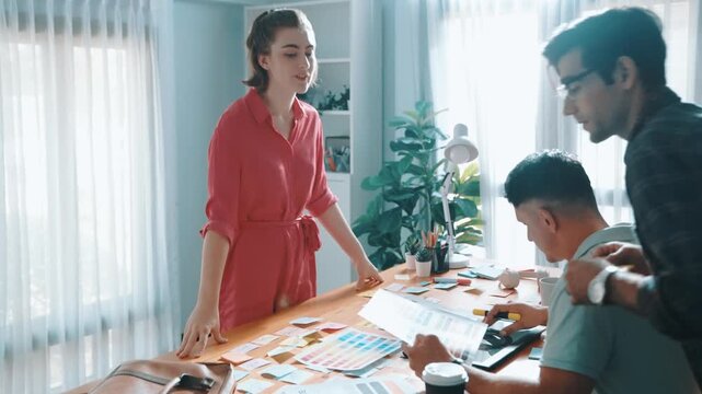 Skilled caucasian business woman present theme color to diverse investor. Multicultural people planning and making decision for choosing color for product while sitting at meeting table. Symposium.