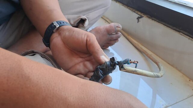Technician connecting electrical wires for outlet using pliers and hot glue gun. Wiring installation and insulation process. Electrician stock video 4K for DIY, renovation, safety, construction, maint