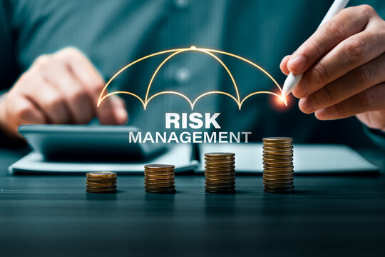 Risk management concept with business hand drawing umbrella protection over growing coin stacks showing financial security investment planning and corporate risk control strategy
