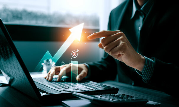 Business financial growth concept with professional using laptop and pointing to rising arrow chart showing revenue strategy investment performance improvement and profit success