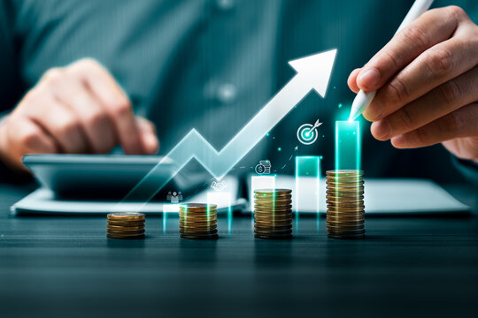 Business financial growth concept with hand using stylus to touch rising digital bar chart over coin stacks showing revenue increase investment strategy and performance success