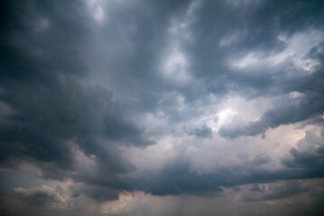 Obraz premium Dark and Moody Thunderstorm Clouds Forming in the Sky Before Heavy Rainfall and Severe Weather, Dark sky with stormy clouds,Dark clouds before a thunder-storm,clouds before rain 