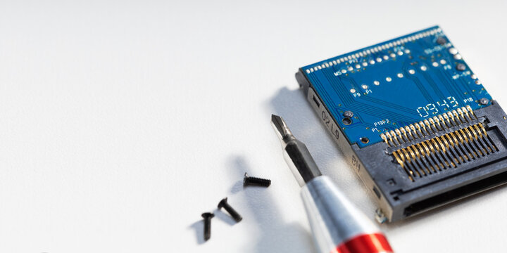 Highprecision electronics repair. Electronic circuit board, microchip and tools on the table. Banner with copy space.