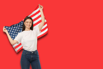 Fototapeta premium Young woman waves American flag proudly. Celebration and patriotism concept