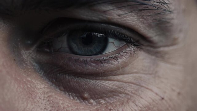 Close up of human eye with detailed skin wrinkles and blue iris texture