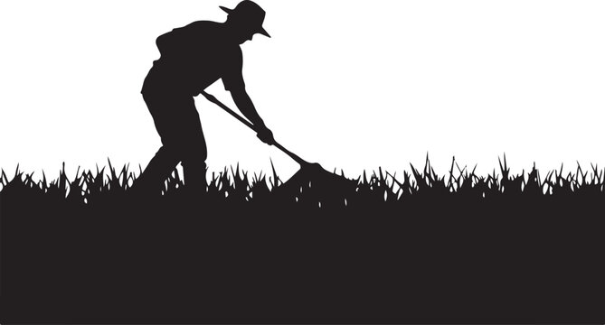 Silhouette of a person raking grass or leaves on a lawn