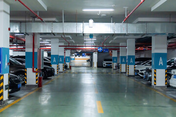 Naklejka premium Underground parking garage with cars and directional signs