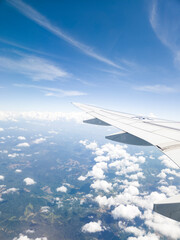 Obraz premium View from an airplane window looking out over beautiful clouds and blue sky during flight.